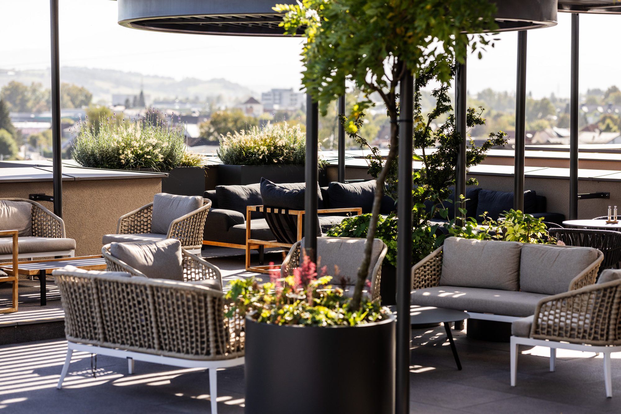 Dachterrasse der HAFNERBAR: Lounge-Möbel und Bepflanzung über den Dächern